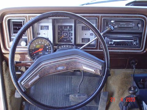 1979 Ford Bronco - The interior of a 1979 Ford Bronco shows its dashboard, steering wheel, and aftermarket tachometer.