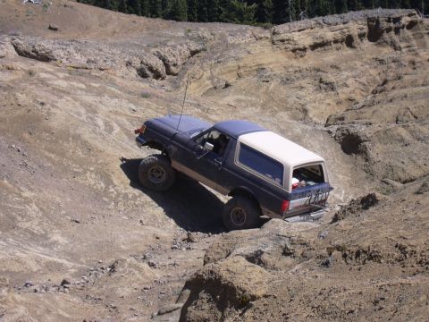 1991 Ford Bronco - This 1991 Ford Bronco navigates a challenging off-road trail with steep, rocky terrain.