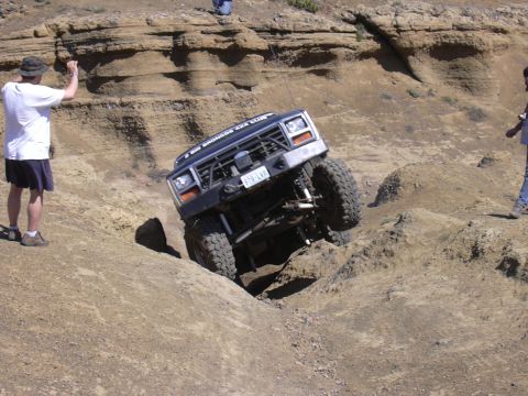 1991 Ford Bronco - Ford Bronco tackling a challenging off-road course, demonstrating its capabilities on rough terrain.