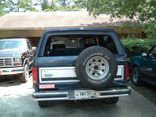 Dark blue 1984 Ford Bronco rear view with spare tire and license plate BW811R