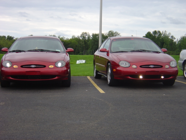 Two red 1998 Ford Taurus sedans parked side-by-side