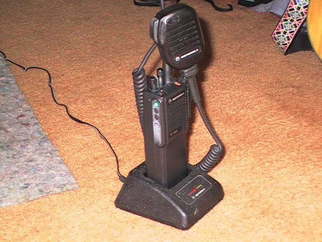 Black Motorola HT1000 radio and microphone on charging base on carpet
