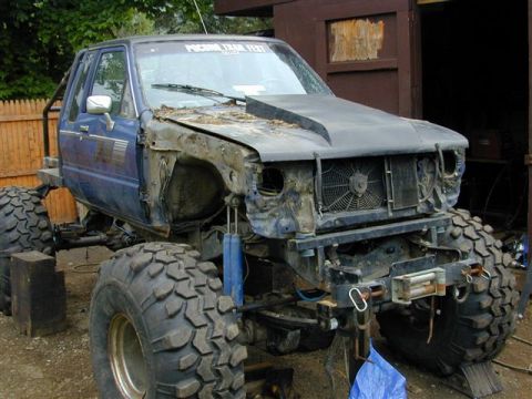 1985 Ford Bronco - This heavily modified truck is undergoing significant work, with many body panels removed.