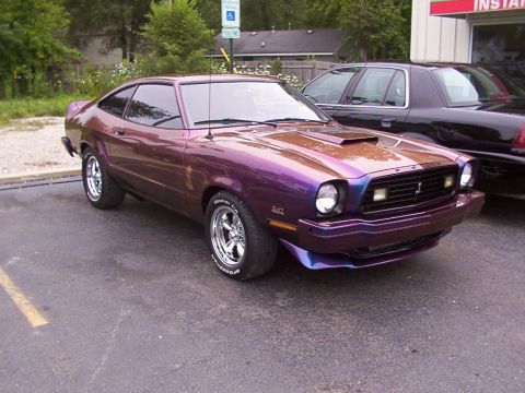 1978 Ford Mustang II - This 1978 Ford Mustang II features a custom purple paint job and a prominent hood scoop, seen here in a three-quarter front view.