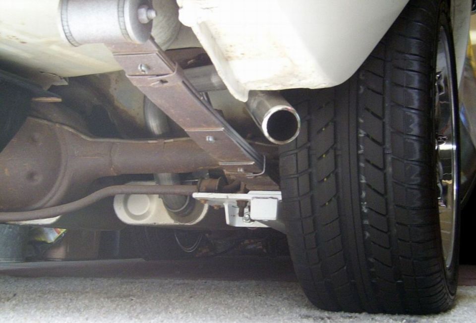 Close-up of a car's rear axle, leaf spring, and exhaust pipe