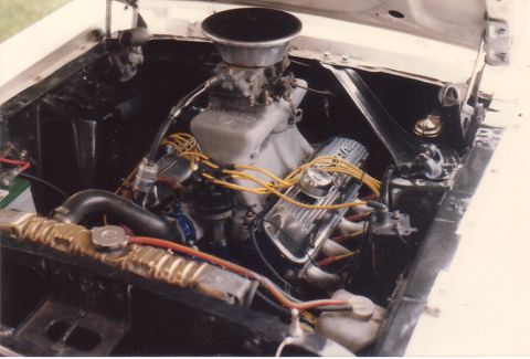 1968 Ford Mustang - Close-up view of a modified V8 engine, showing the carburetor, intake manifold, and spark plug wires.