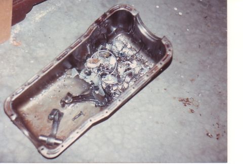 1968 Ford Mustang - A severely damaged oil pan lies on the floor, filled with broken engine components and debris.