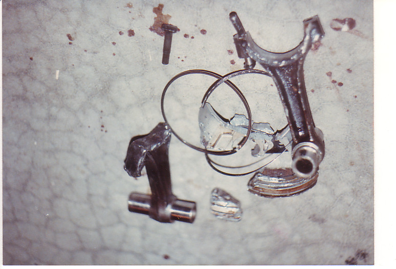 Broken connecting rod and piston rings on concrete floor
