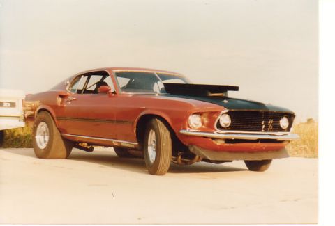 1968 Ford Mustang - This modified Mustang features a prominent hood scoop and roll cage, indicating its drag racing purpose.