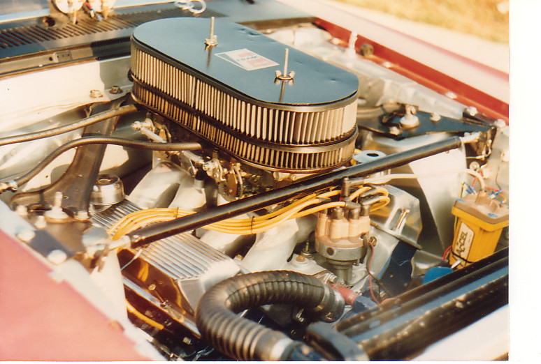 Red 1968 Ford Mustang engine bay with chrome air cleaner and yellow spark plug wires