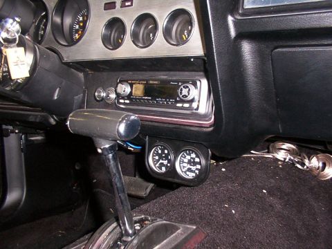 1978 Ford Mustang II - The interior of a 1978 Ford Mustang II, a dashboard with gauges, a radio, and a gear shifter.