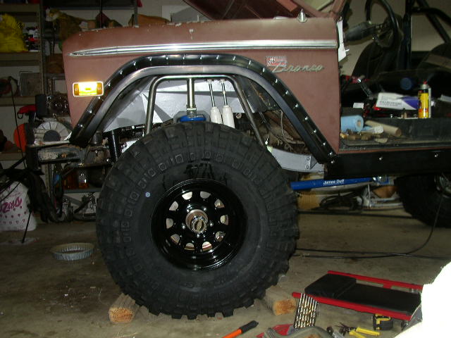 Ford Bronco fender with large off-road tire mounted, showing roll cage modifications