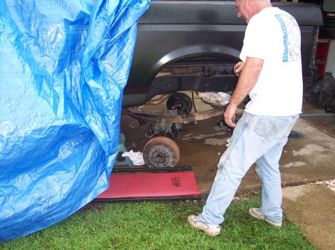 1990 Ford Bronco - A man works on the rear suspension of a Ford Bronco, which appears to be from the early 1980s.