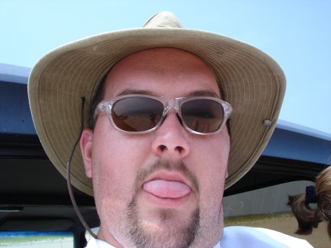 1987 Ford Bronco - A man wearing a hat and sunglasses makes a face for the camera.