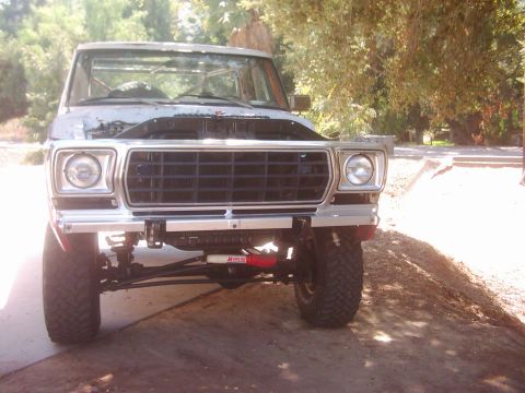 1978 Ford Bronco - Front view of a gray Ford truck with its hood open, showing a chrome grille and aftermarket bumper.