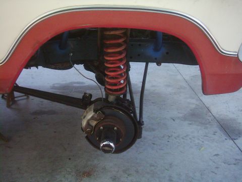 1978 Ford Bronco - Front suspension and wheel well detail of a vehicle, showing the brake system and coil spring.