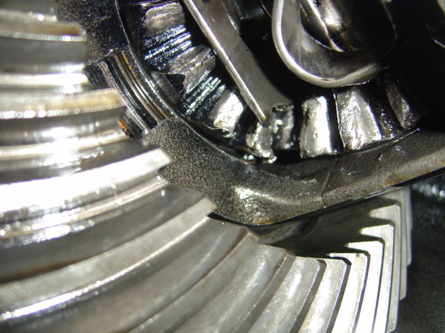 Close-up of damaged differential gears with a tool inserted