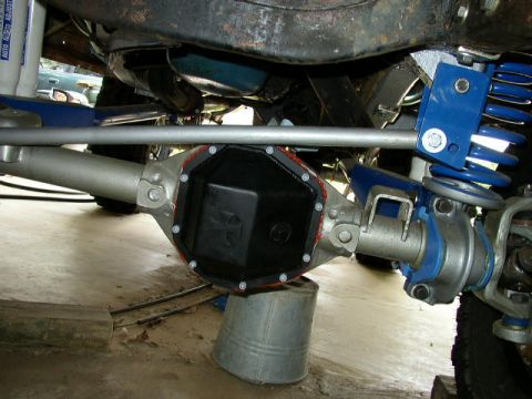 1995 Ford Bronco - The underside of a vehicle shows a newly installed differential cover with a prominent cross emblem.