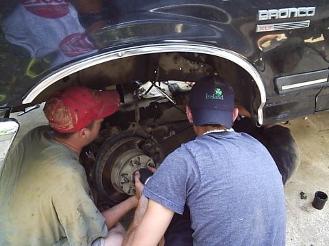 1989 Ford Bronco - Mechanics work on the suspension of a 1989 Ford Bronco during a lift party.