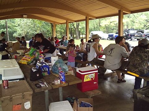 1989 Ford Bronco - A group enjoys a cookout under a pavilion with several SUVs and trucks visible in the background.