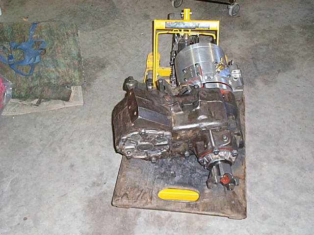 Manual transmission and transfer case assembly sitting on a pallet in a shop