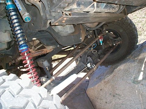 1994 Ford Bronco - Close-up view of the suspension system of an off-road vehicle navigating a rocky landscape.