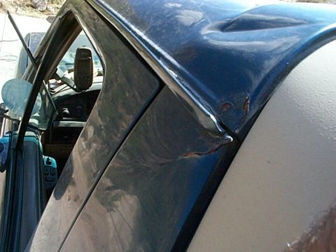 1994 Ford Bronco - Damage to the door frame of a vehicle, showing rust and dents.