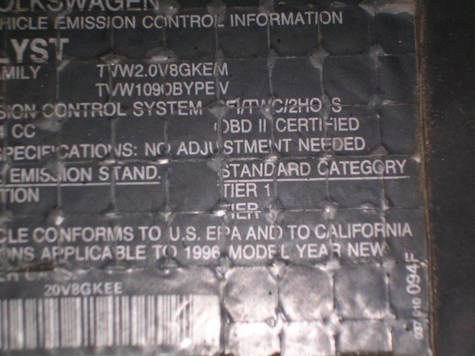 Close-up of a Volkswagen vehicle emission control information sticker showing '1996 MODEL YEAR NEW'