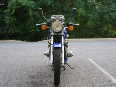 1985 Ford Crown Victoria LTD - This motorcycle is parked on a paved surface with trees visible behind it.