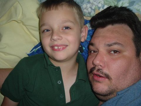1993 Ford Taurus - A man and a child are taking a selfie together. The child has a gap between his front teeth.