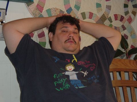 1993 Ford Taurus - A man rests with his hands behind his head, wearing a dark t-shirt a child's drawing and text.
