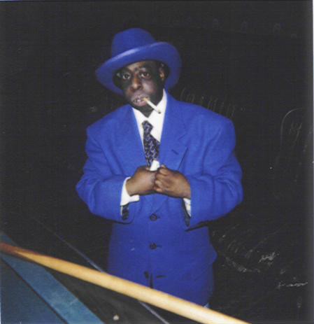 1993 Ford Bronco - A man dressed in a blue suit and matching hat poses for a photo while smoking.