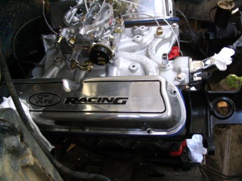 1984 Ford Bronco - Close-up of a chrome Ford Racing valve cover on an engine, with a carburetor visible above.