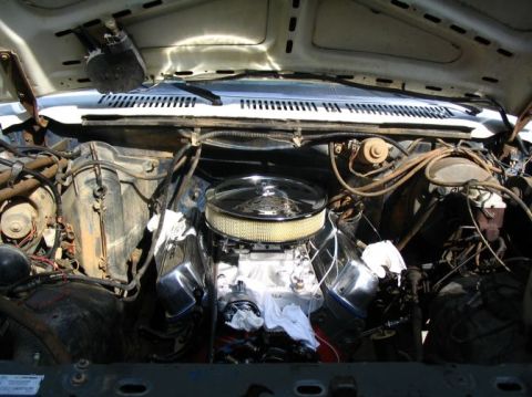 1984 Ford Bronco - The engine bay shows a V8 engine with aftermarket chrome components and a large air filter.