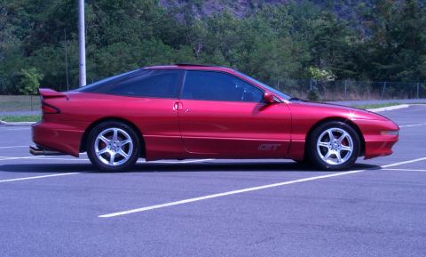 1996 Ford Probe - Side profile of a red 1996 Ford Probe GT in a parking lot.