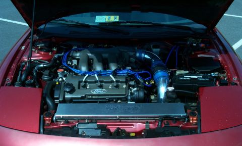 1996 Ford Probe - Engine bay of a 1996 Ford Probe, showing the V6 engine with custom blue intake piping.