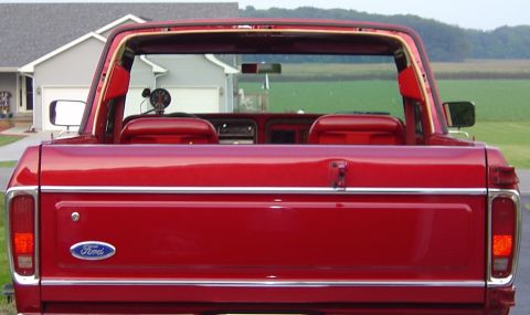 1978 Ford Bronco - Rear view of a red 1978 Ford Bronco, showing the tailgate, taillights, and interior.
