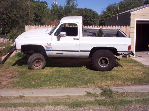 1988 Ford Bronco - This lifted pickup truck features large off-road tires and a '130 4WP' decal on the fender.