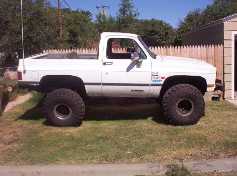 1988 Ford Bronco - This white pickup truck features large off-road tires and a 4WD badge, suggesting it is modified for off-road use.
