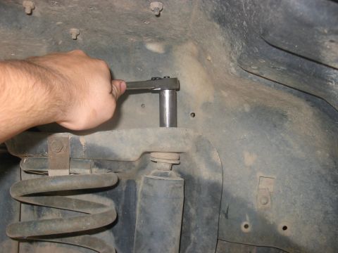 1988 Ford Bronco - Working on vehicle suspension components, likely a lift install.