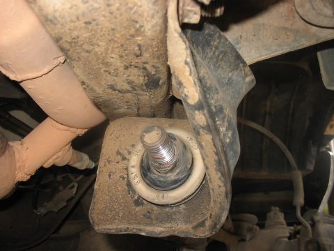 1988 Ford Bronco - Underside view of a vehicle's suspension system, focusing on a worn bushing and bolt.