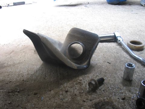 1988 Ford Bronco - A vehicle suspension part and tools are laid out on a concrete surface, likely during maintenance or installation.
