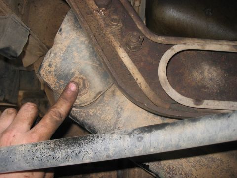 1988 Ford Bronco - A close-up view of a vehicle's undercarriage, focusing on a suspension component and a bolt.