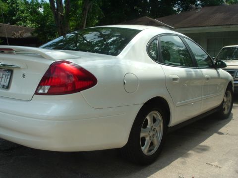2003 Ford Taurus - Rear view of a white 2003 Ford Taurus sedan parked outside a house.
