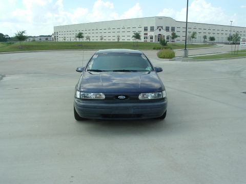 1993 Ford Taurus - This 1993 Ford Taurus is captured from a front-facing perspective in a parking lot.