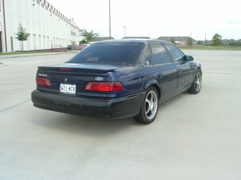 1993 Ford Taurus - Rear three-quarter view of a dark blue second-generation Ford Taurus SHO sedan with black lower cladding, SHO lettering on the rear bumper,…