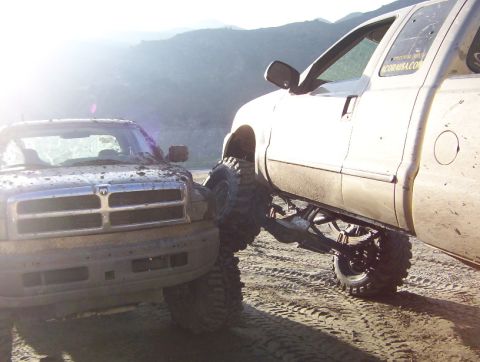 2000 Ford F-450 - Two heavily modified trucks are stuck in the mud off-road.