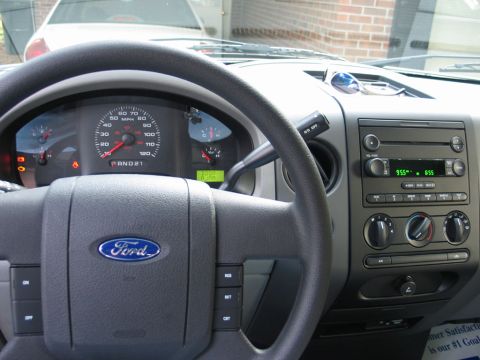 2004 Ford F-150 - The interior of a Ford F-150 shows the steering wheel, instrument cluster, and center console.