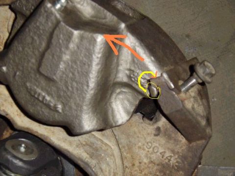1979 Ford Bronco - A close-up view of a vehicle's brake caliper assembly, highlighting specific components with markings.