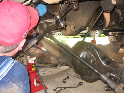 1988 Ford Bronco - Undercarriage view of a vehicle undergoing repair, with focus on suspension and steering parts.